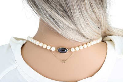 Lot 56 - A CULTURED PEARL NECKLACE, with oval garnet...