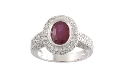 Lot 214 - A RUBY AND DIAMOND CLUSTER RING, the oval ruby...