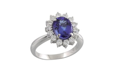 Lot 216 - A TANZANITE AND DIAMOND CLUSTER RING, the oval...