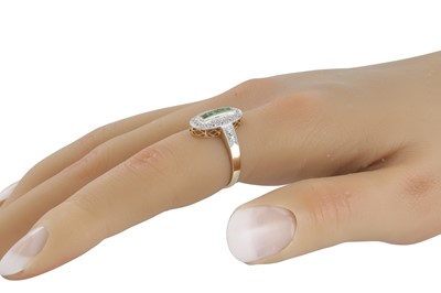 Lot 63 - A DIAMOND AND EMERALD OVAL SHAPED RING, the...