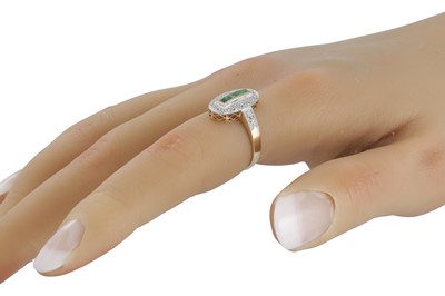 Lot 63 - A DIAMOND AND EMERALD OVAL SHAPED RING, the...