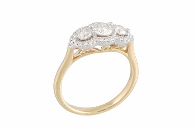 Lot 320 - A DIAMOND TRIPLE 'HALO' CLUSTER RING, set with...