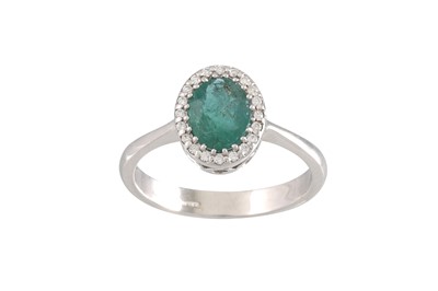 Lot 256 - AN EMERALD AND DIAMOND CLUSTER RING, oval form...
