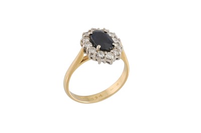 Lot 141 - A DIAMOND AND SAPPHIRE CLUSTER RING, in oval...