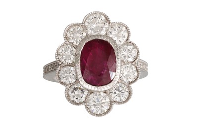 Lot 220 - A RUBY AND DIAMOND CLUSTER RING, the oval ruby...