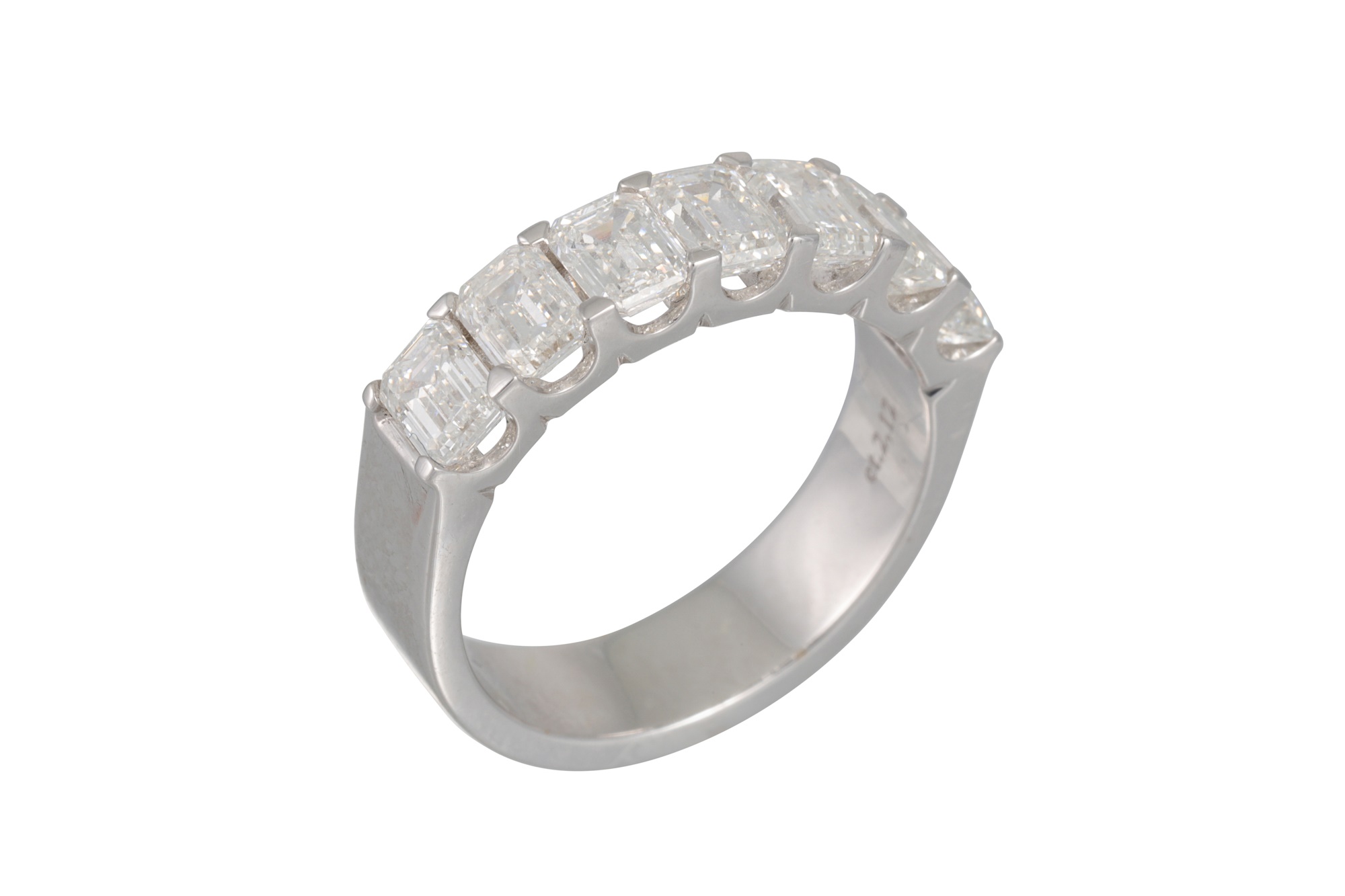 Lot 163 AN EMERALD CUT DIAMOND HALF ETERNITY RING,