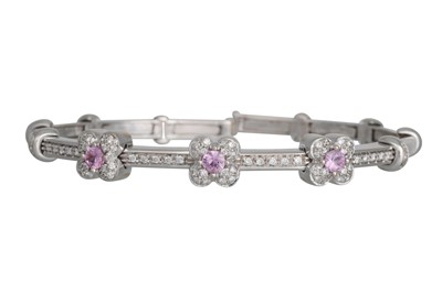 Lot 207 - A DIAMOND AND PINK SAPPHIRE BANGLE, of cluster...
