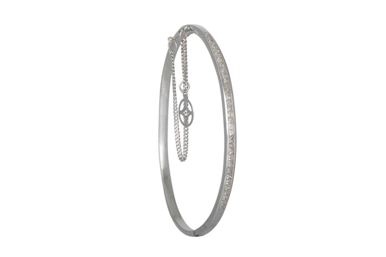 Lot 394 - A DIAMOND BANGLE, channel set with princess...