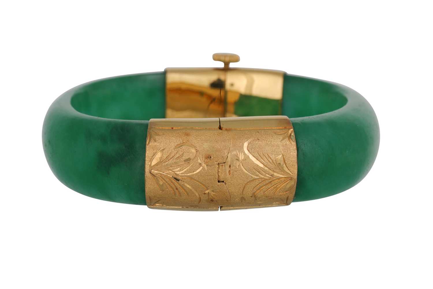 Lot 37 - A CARVED JADE BANGLE, gold mounts with...