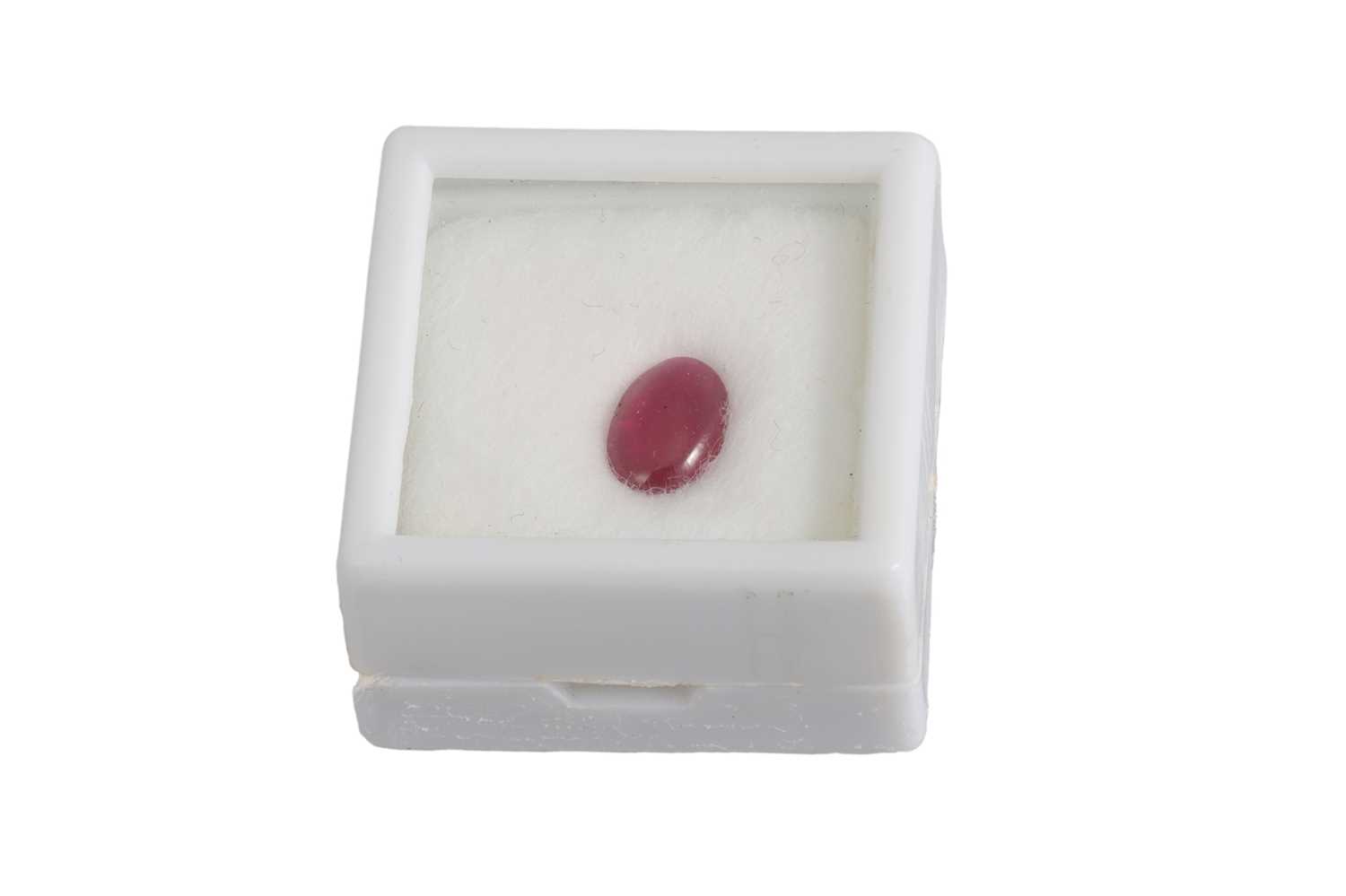 Lot 145 - AN UNMOUNTED CABOCHON RUBY, of oval form,...