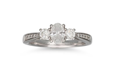 Lot 439 - A THREE STONE DIAMOND RING, the central oval...