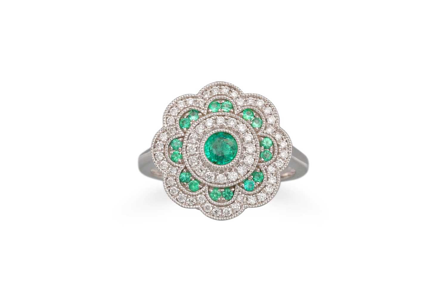 Lot 102 - A DIAMOND AND EMERALD CLUSTER RING, in the...
