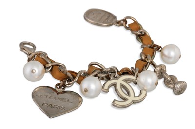 Lot 21 - A CHANEL CHARM BRACELET, leather and chain,...