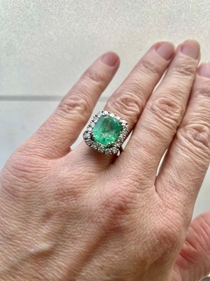 Lot 214 - AN EMERALD AND DIAMOND CLUSTER RING, the...