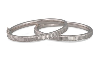 Lot 416 - A PAIR OF PLATINUM HINGED BANGLES, with bright...
