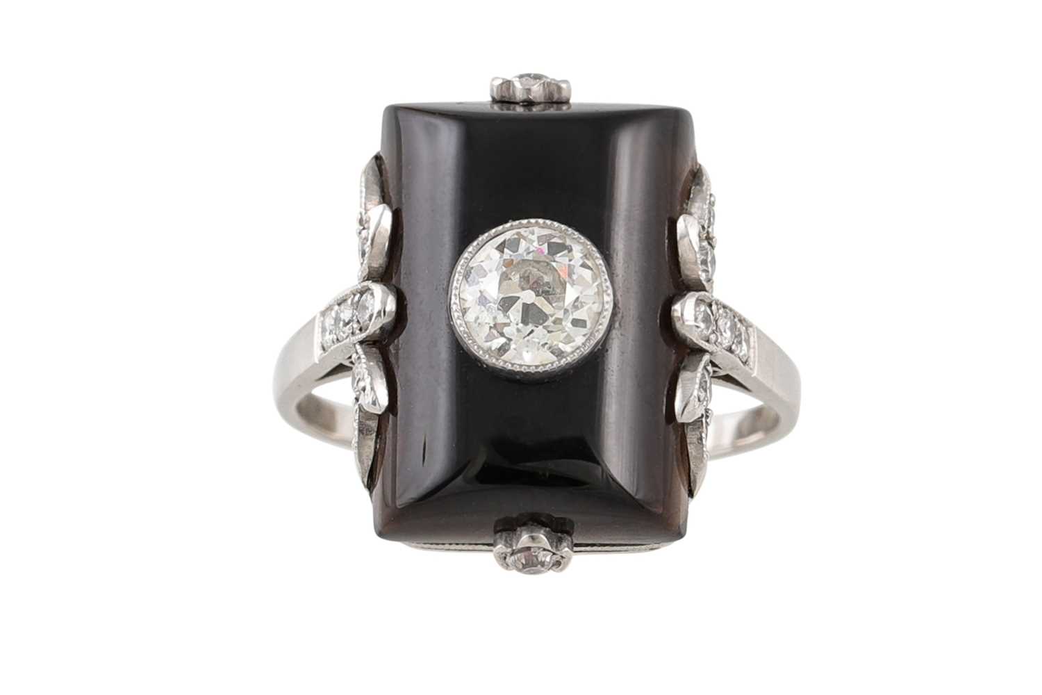 Lot 366 - AN ONYX AND DIAMOND PLAQUE RING, in a white...