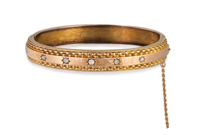 Lot 352 - AN ANTIQUE 15CT GOLD HINGED BANGLE, set with...