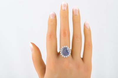 Lot 60 - A SAPPHIRE AND DIAMOND CLUSTER RING, the oval...