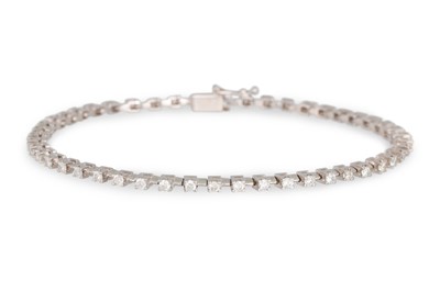 Lot 411 - A DIAMOND LINE BRACELET, the brilliant cut...