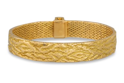 Lot 333 - AN 18CT GOLD BANGLE, circa 1970s, of textured...