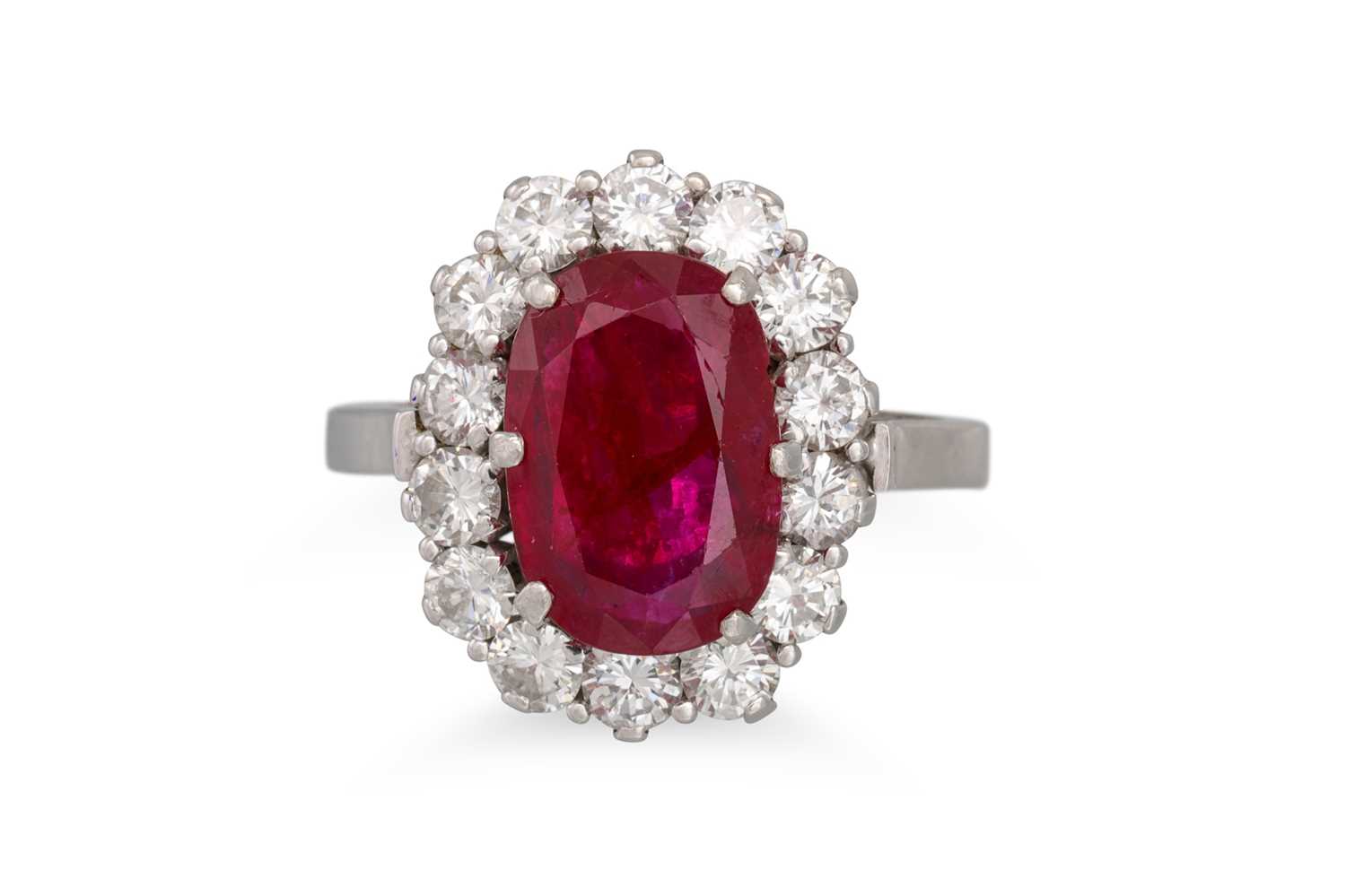 Lot 349 - A RUBY AND DIAMOND CLUSTER RING, the oval ruby...