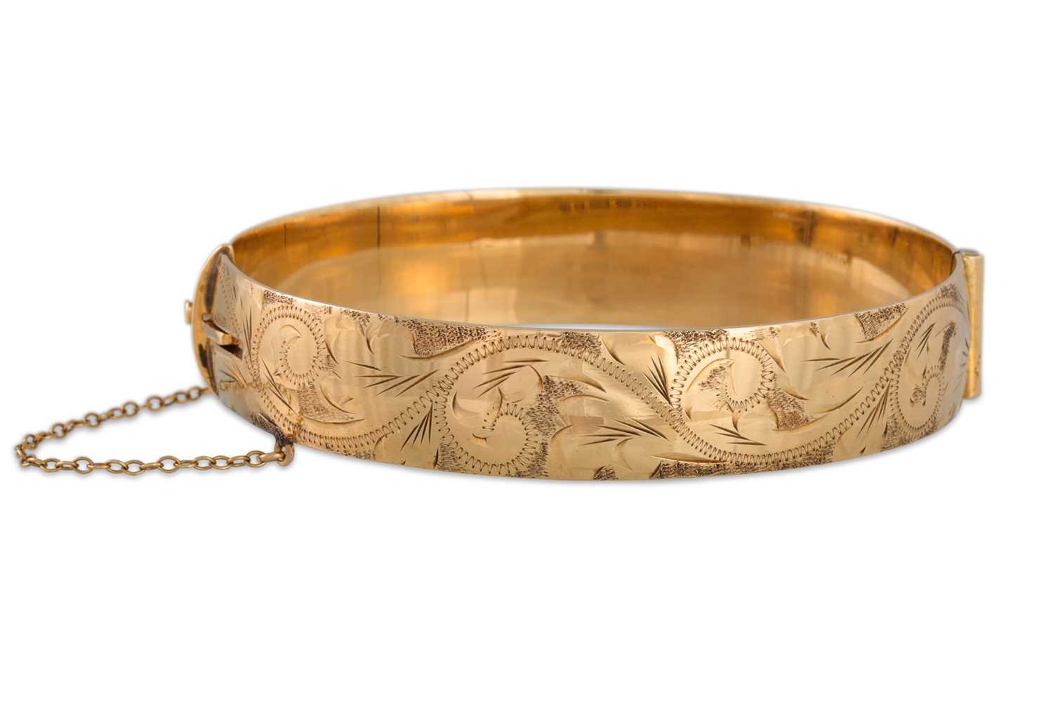 Lot 4 - A 9CT GOLD BANGLE, engraved decoration, 36 g.