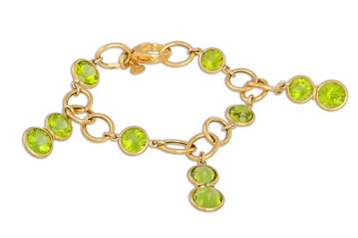 Lot 296 - A PERIDOT BRACELET, the circular peridots...