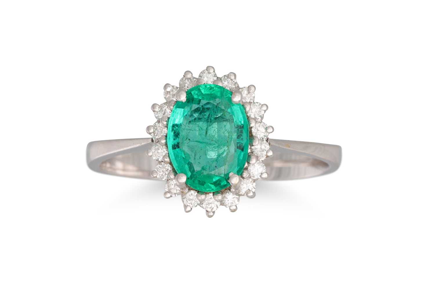 Lot 244 - A DIAMOND AND EMERALD CLUSTER RING, the oval...