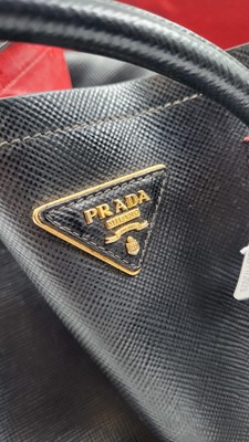 Lot 527 - A BLACK PRADA HANDBAG, double leather, red lining