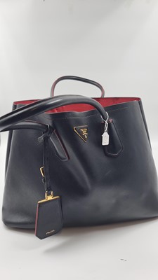 Lot 527 - A BLACK PRADA HANDBAG, double leather, red lining